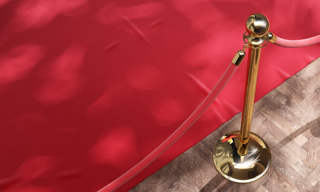 Red event carpet and golden barrier with red rope. Luxury, equipment for events, VIP concept. 3d illustration